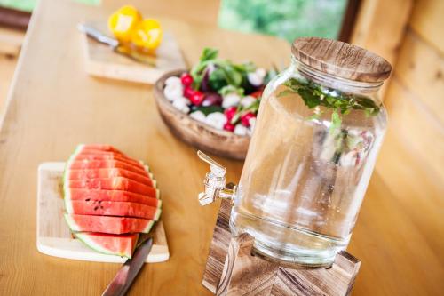 einen Tisch mit einem Glas Wassermelone und einem Teller Salat in der Unterkunft Apartmány Pinus, Tále, Chopok Juh in Tale