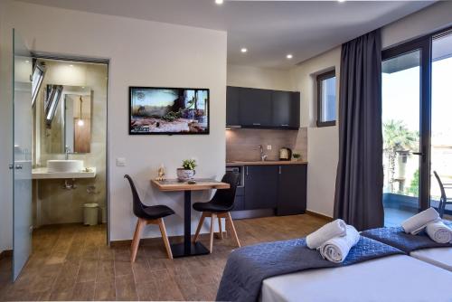 a bedroom with a bed and a table and a kitchen at Del Mar 'Adults Only' in Stalida
