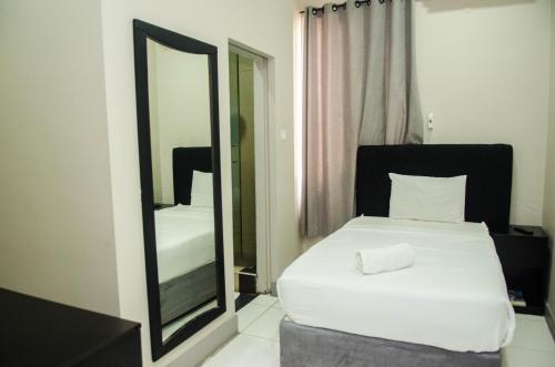 a bedroom with a white bed and a mirror at Residencial Horizonte 2 in Maputo
