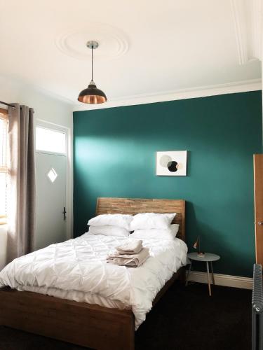 a bedroom with a green wall and a bed at Stylish 1-Bedroom Apartment in Chapel Allerton with Free Parking in Moortown
