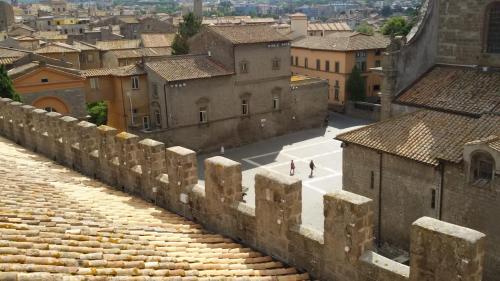 two people walking on a wall in a city at Il Gallo Nero in Viterbo