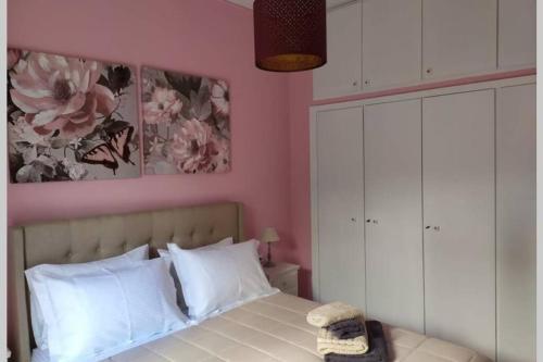 a bedroom with pink walls and a bed with white pillows at IRIS by Amanakis Family in Hersonissos