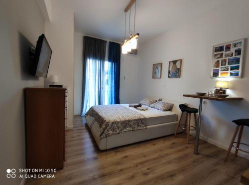- une chambre avec un lit, une table et une télévision dans l'établissement Studio in Kallithea next to Kiprou square, à Athènes