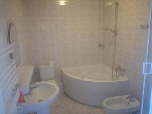 ein Badezimmer mit einer Badewanne, einem WC und einem Waschbecken in der Unterkunft Restauracja - Hotel Nova in Skępe