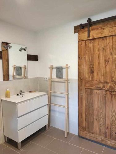 a bathroom with a sink and a wooden door at Villa Rosalía in Villanúa