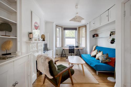 uma sala de estar com um sofá azul e uma mesa em Pass the Keys - Beautiful stylish flat in South West London em Londres