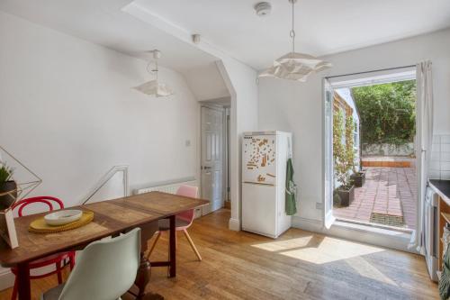 een keuken en eetkamer met een tafel en een koelkast bij Pass the Keys - Beautiful stylish flat in South West London in Londen