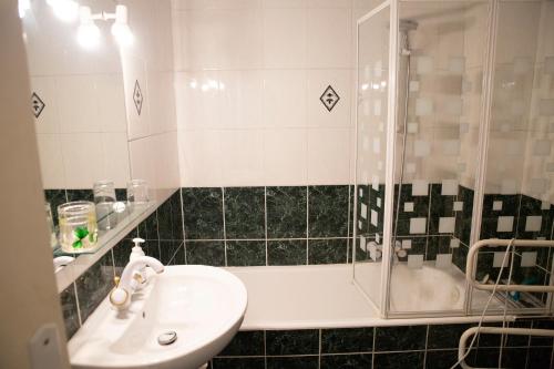 La salle de bains est pourvue d'un lavabo et d'une douche. dans l'établissement Chill Out Apartment, 2 mins from beach, à Nice