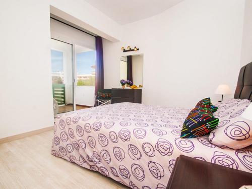 een slaapkamer met een groot bed met een roze sprei bij Apartment Xara Torres, at the Beach of Alcudia in Port d'Alcudia