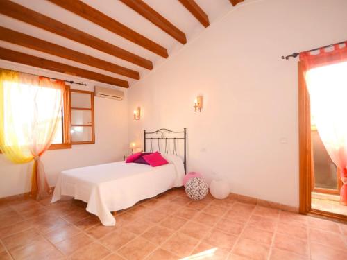 House Sant Jaume في الكوذيا: غرفة نوم بسرير ابيض في غرفة