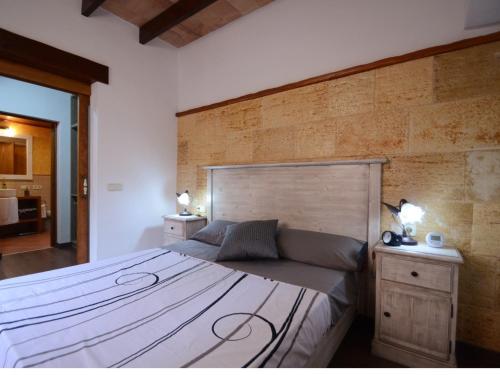 a bedroom with a large bed with a wooden headboard at House Ca Na Polida in Alcudia