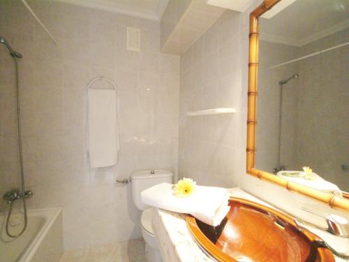 a bathroom with a tub and a toilet and a mirror at Apartamento Arcoiris, con piscina y junto a playa de Alcudia in Alcudia