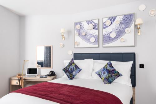 a bedroom with a large bed and a large window at Hotel Indigo Manchester - Victoria Station, an IHG Hotel in Manchester