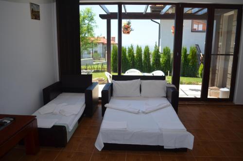 a living room with a couch and a table and windows at Villa on the Black Sea in Sunny Beach