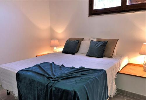 - une chambre avec un lit doté d'une couverture bleue dans l'établissement Domus Claudia, à Villasimius