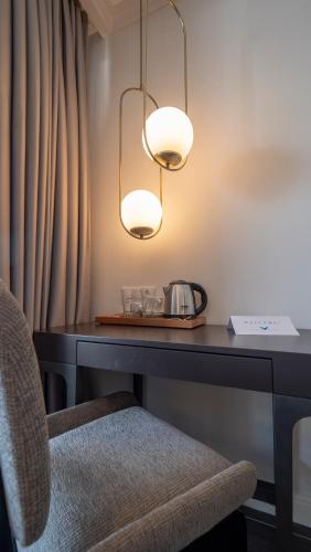 a desk with a chair and a lamp at Vivid Blue Serenity Resort in Sveti Stefan