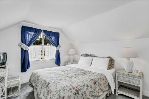 a bedroom with a bed with blue curtains and a window at 201 Amethyst Avenue in Newport Beach