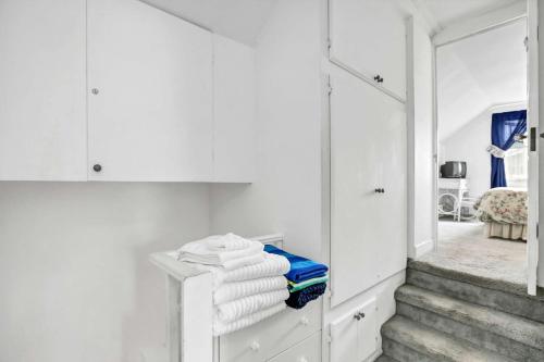 a room with white cabinets and stairs with towels at 201 Amethyst Avenue in Newport Beach