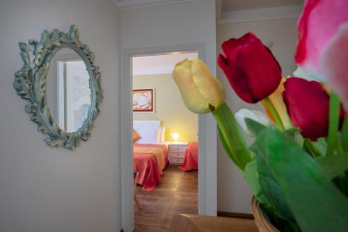 a bedroom with a mirror and a bed with roses at La Dimora dei Tribbi in Rapolano Terme