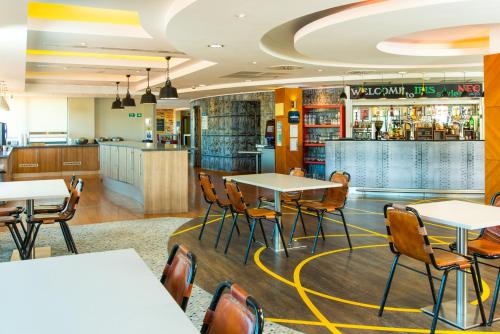 a restaurant with tables and chairs and a bar at ibis Styles Birmingham NEC & Airport in Bickenhill