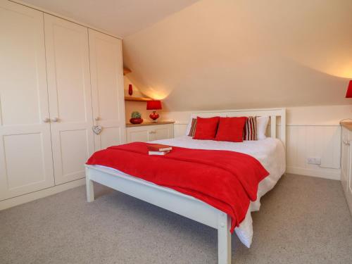a bedroom with a large bed with red pillows at 3 Lowerbourne Terrace in Minehead