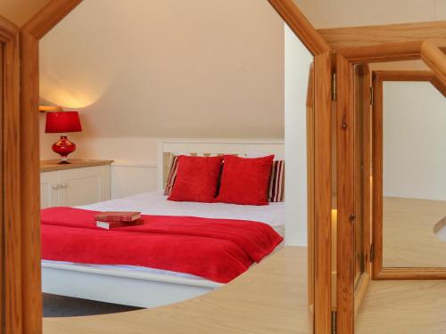 a bedroom with a bed with red pillows at 3 Lowerbourne Terrace in Minehead