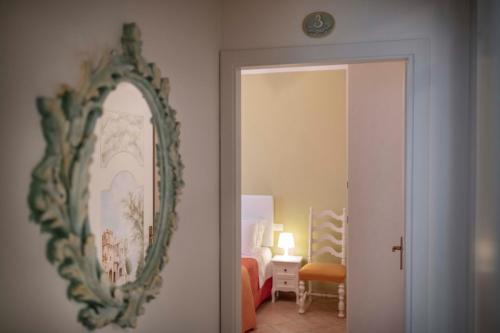 a mirror hanging on a wall next to a bedroom at La Dimora dei Tribbi in Rapolano Terme
