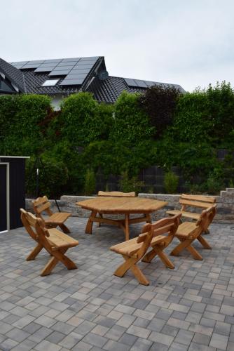 un grupo de mesas de picnic y bancos en un patio en hunsruecker-fewo - Die Erlebnishütte - 2 Ferienwohnungen im Hunsrück in Unzenberg en Göbenhausen