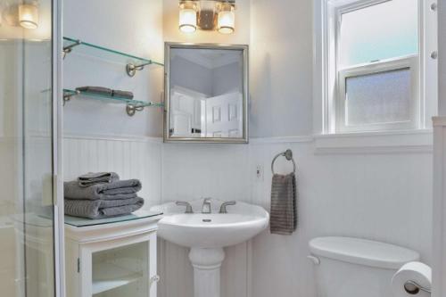 a white bathroom with a sink and a mirror at 307 Thirty Fifth Street in Newport Beach