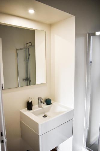 a bathroom with a white sink and a mirror at A Casa do Outeiro in Ribeira Grande