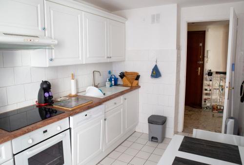 a kitchen with white cabinets and a sink at Chill Out Apartment, 2 mins from beach in Nice