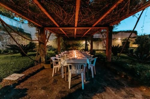 リベイラ・グランデにあるA Casa do Outeiroの長テーブル(パーゴラの下の白い椅子付)