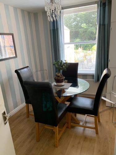 comedor con mesa, sillas y ventana en Gillygate Holiday Apartment, en York