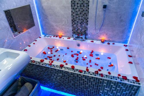 a bathroom with a tub filled with red hearts at Aphrodite Suites in Bradford