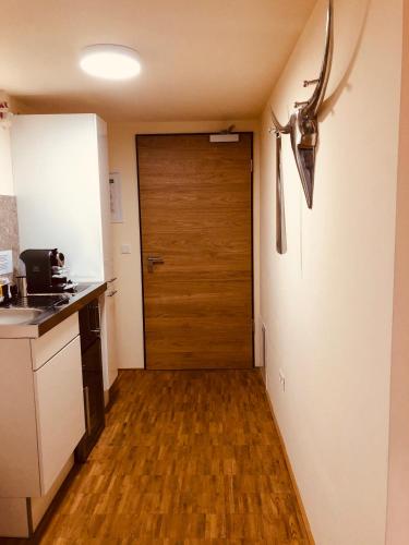 a kitchen with a door and a wooden floor at Apartmenthotel Oberstdorf in Oberstdorf