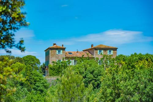 an old house on top of a hill with trees at Bastide Saint-Estève in Brue-Auriac