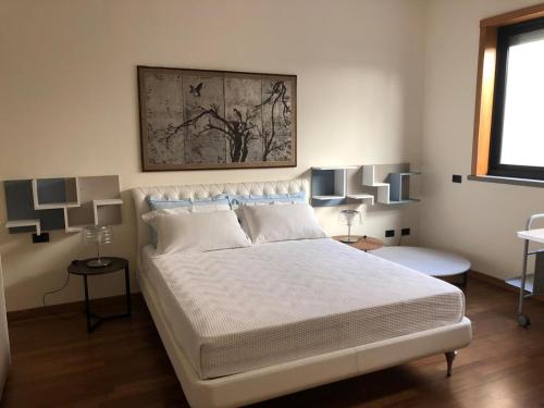 - une chambre avec un grand lit blanc et deux lampes dans l'établissement Lanna b&b, à Novoli