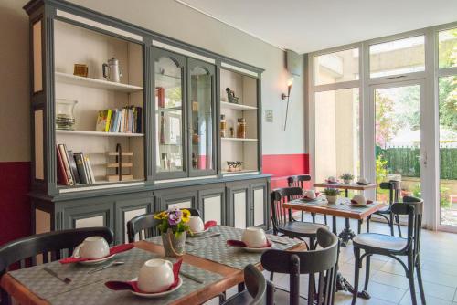 a dining room with tables and chairs and a book shelf at Hotel du Forum in Carpentras