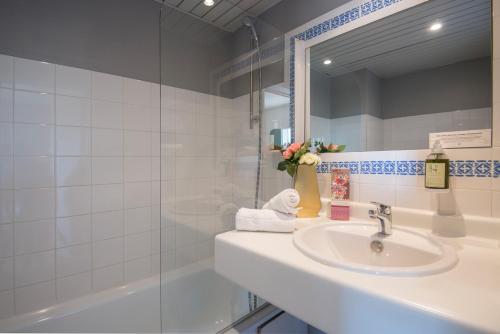 a bathroom with a sink and a mirror and a tub at Hotel du Forum in Carpentras