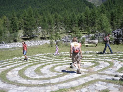 a group of people walking around a large stone labyrinth at Residence Flora in Solda