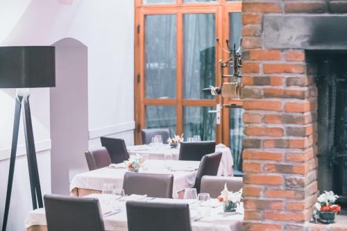 a row of tables with white tablecloths and chairs at Au Bon Gîte in Senones
