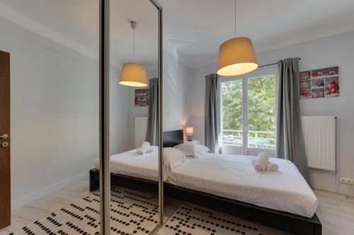 une chambre avec deux lits et un grand miroir dans l'établissement Le Baulier - 2 bedrooms apartment, à Annecy