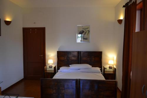 - une chambre avec un lit et deux lampes sur deux tables dans l'établissement Agriturismo Le Forre del Treja (La Villa), à Civita Castellana