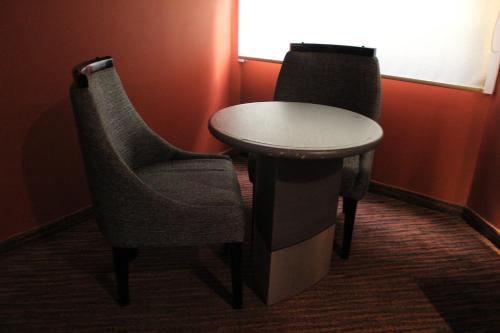 two chairs and a table in a room at Hotel Lua in Mexico City
