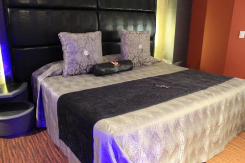 a bed with a black bag sitting on top of it at Hotel Lua in Mexico City
