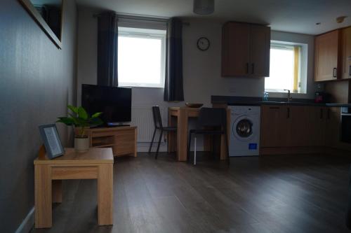 a living room with a kitchen and a table with a dining room at Chapel Court Apartments in Cannock