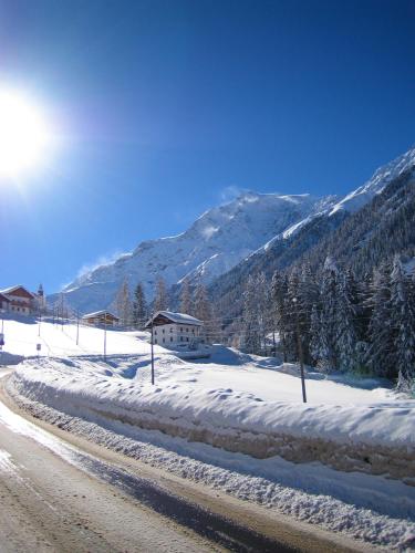 a snow covered road with a mountain in the background at Residence Flora in Solda