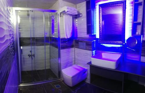 a bathroom with a pink sink and a shower at Ünaten otel in Gaziemir