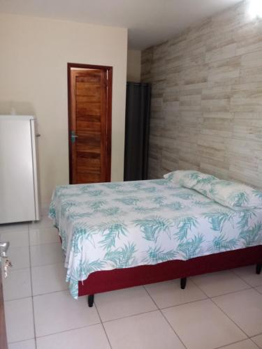 a bedroom with a bed and a refrigerator in it at Pousada Chalé Mar Rio in Galinhos