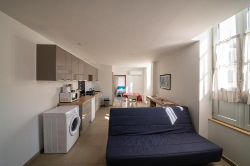 ein Wohnzimmer mit einer blauen Couch in einer Küche in der Unterkunft Du Large in Bayonne